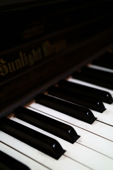 Close-up of piano keys and brand logo on a high-end acoustic piano in a refined setting