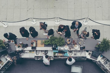 aerial view photography of people lining-up at the food counter