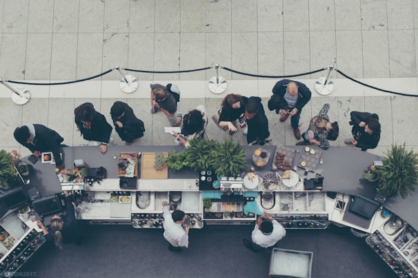 aerial view photography of people lining-up at the food counter