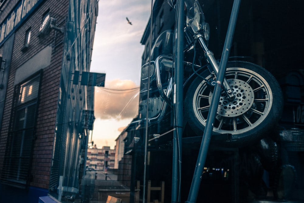 black motorcycle beside blue pole during daytime