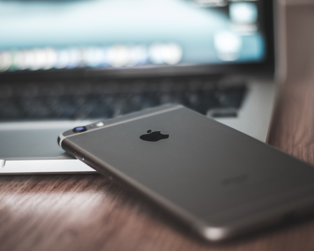 space gray iPhone 6 on MacBook laptop