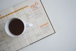 Weekly meal planner notebook with coffee