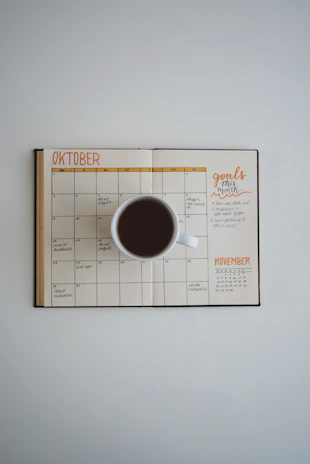 Close-up of a colorful business planner open with handwritten notes and a cup of coffee nearby.