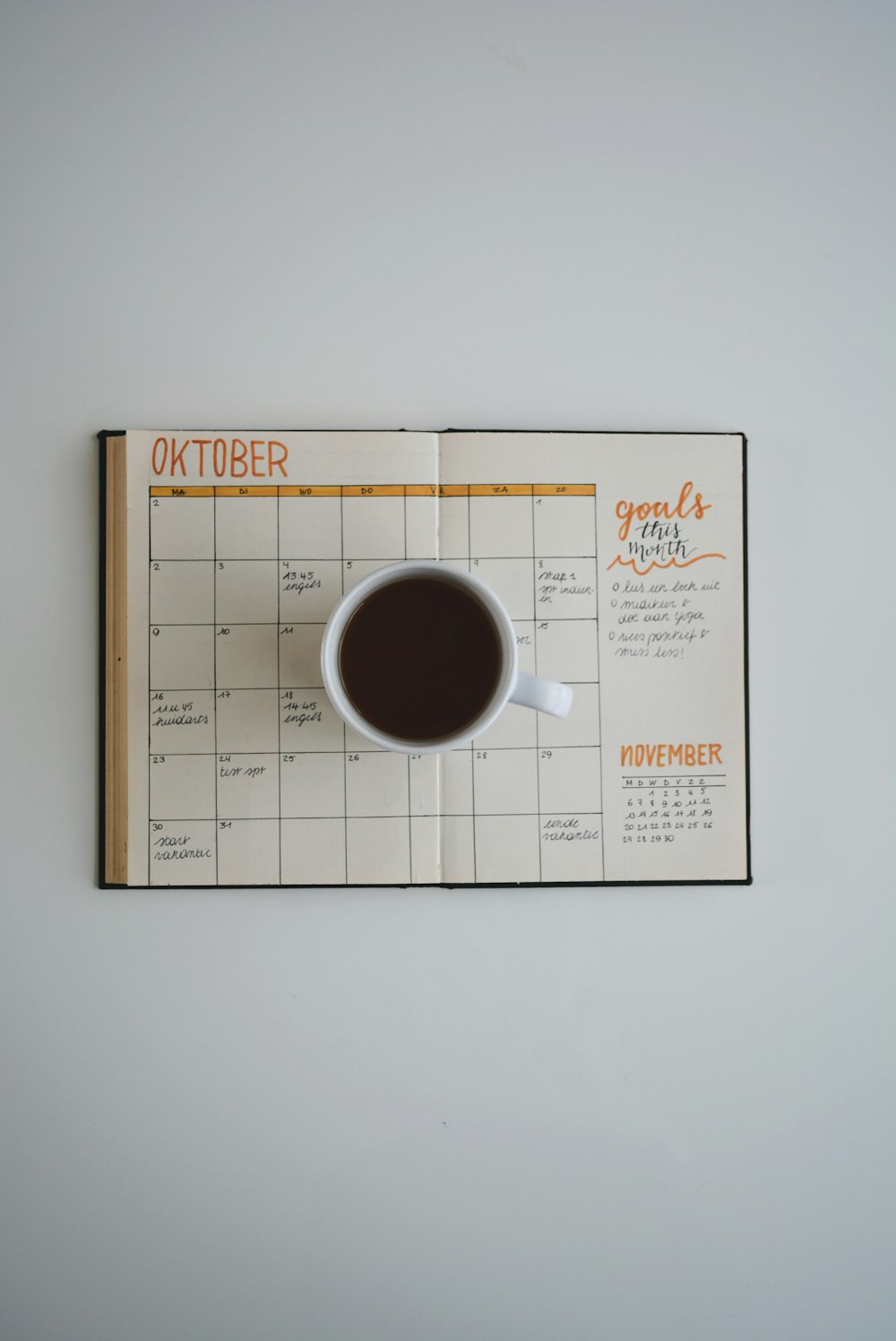white coffee mug on calendar at october