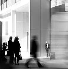 grayscale photo of people walking towards building