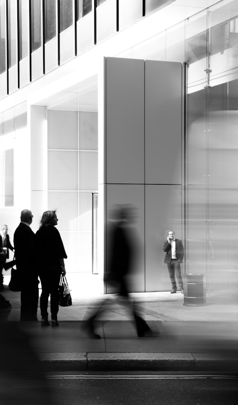 grayscale photo of people walking towards building