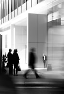 grayscale photo of people walking towards building