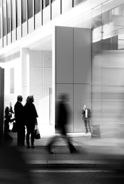 grayscale photo of people walking towards building