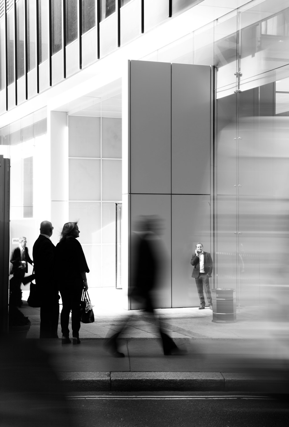 grayscale photo of people walking towards building