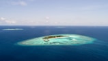 Aerial view of the private island surrounded by turquoise Bahamian waters under a clear blue sky.