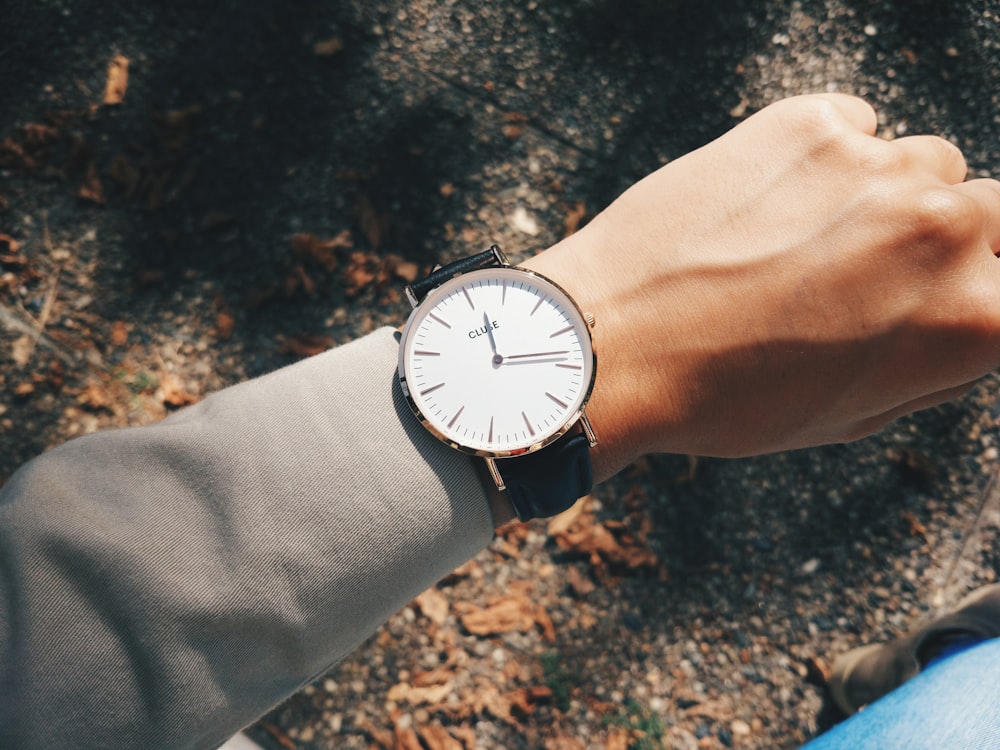 Persona che indossa un orologio analogico rotondo color argento a 1:19
