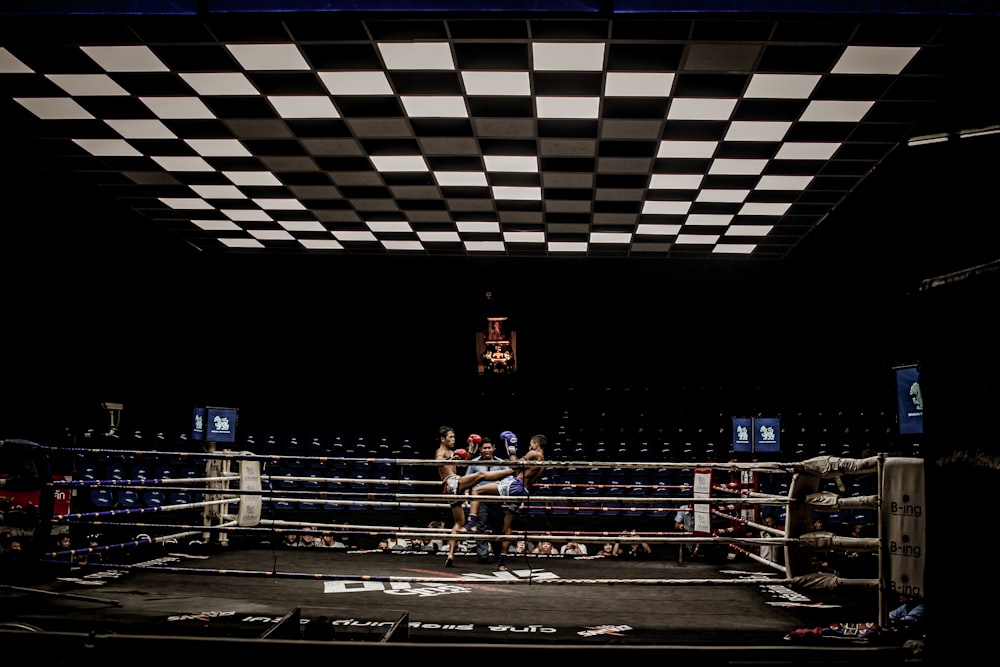 Dos hombres en azul y rojo par de guantes en el ring de boxeo
