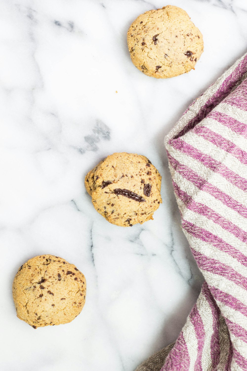 three round chocolate cookies on white surface