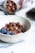 Close-up of a bowl filled with Brasiliana granola topped with fresh fruits and a drizzle of honey.