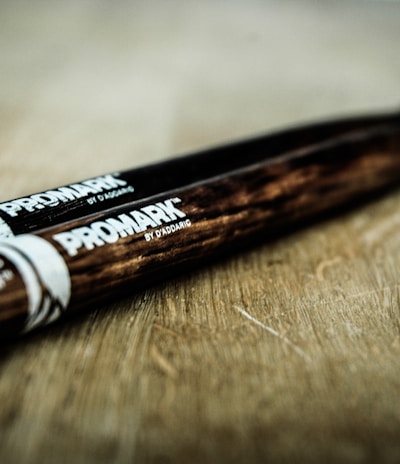 close-up photography pair of black and brown Promark drum sticks