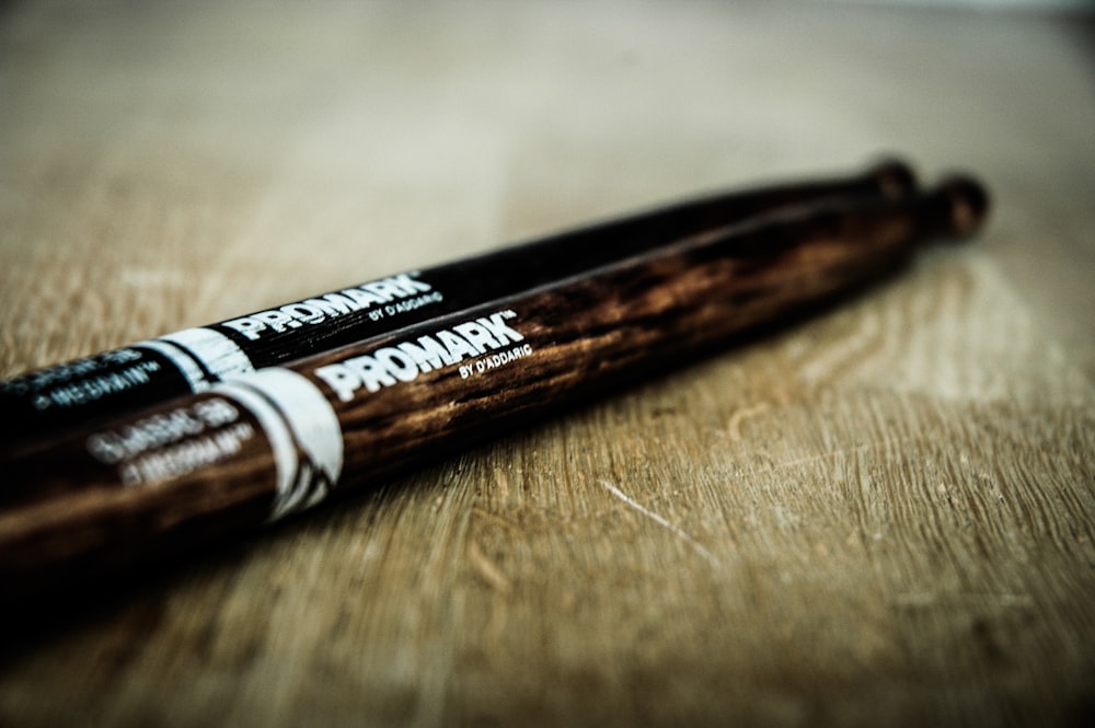 close-up photography pair of black and brown Promark drum sticks