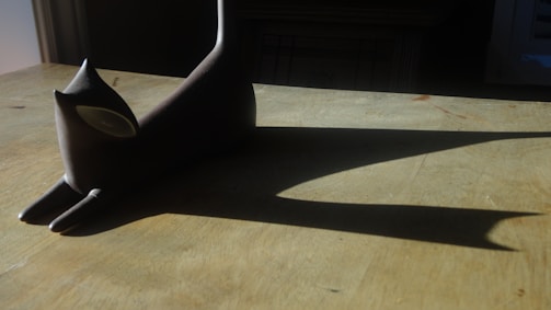 Elegant feline sculpture in black with golden highlights, minimalist style.