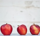 five red apples on white surface