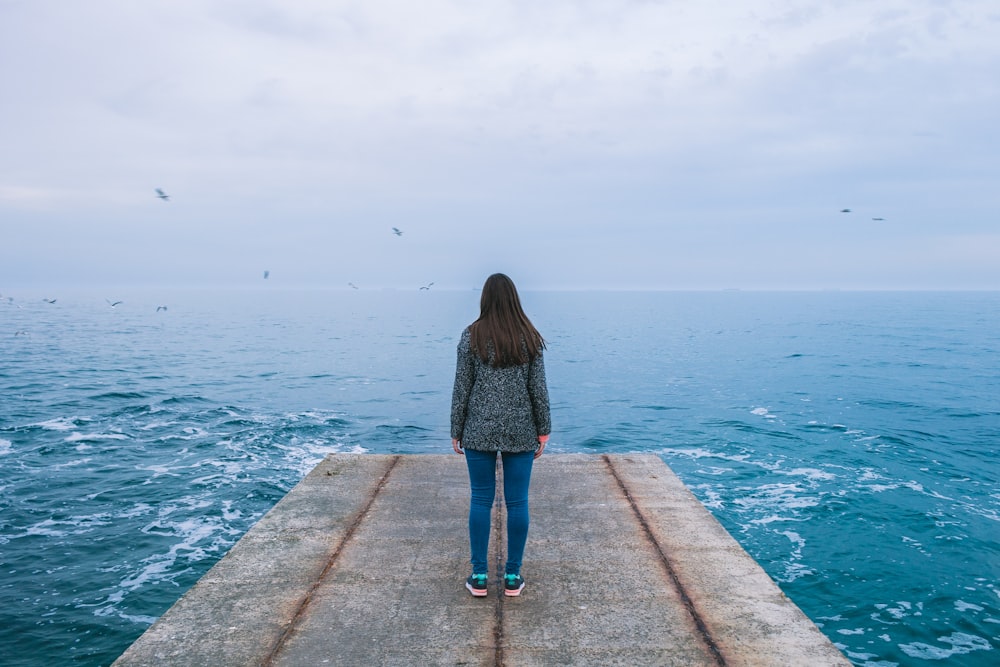 woman on dock with body of water