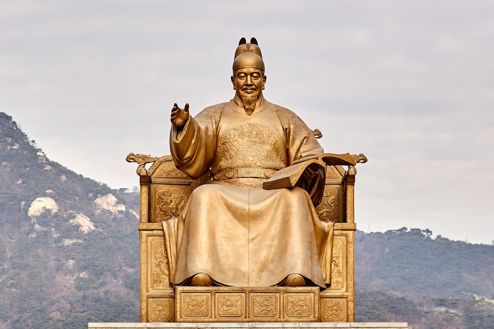 statue en or d’un homme assis sur un trône