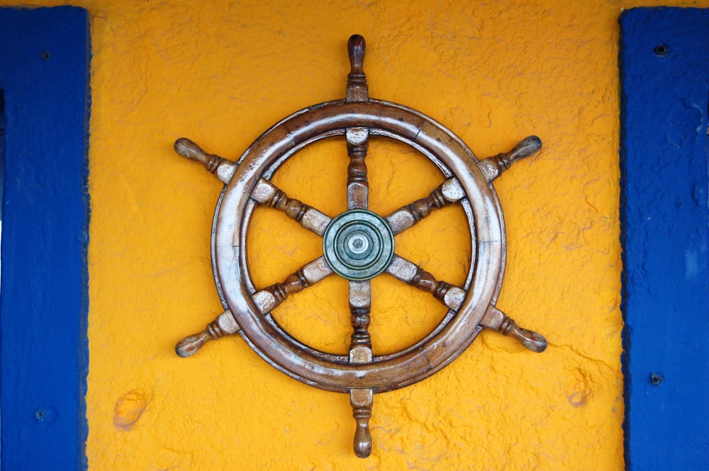 壁に茶色の船の舵輪