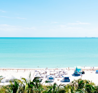 white sand beach with stalls under blue sky