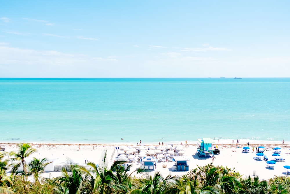 white sand beach with stalls under blue sky