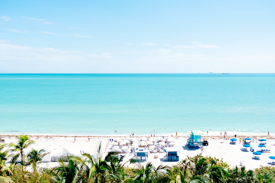 white sand beach with stalls under blue sky,