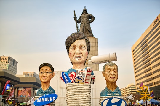 view photography of three human floats in Gwanghwamun Gate South Korea