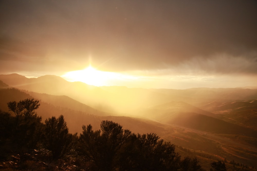 silhouette of trees and mountains during sunrise