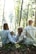 man and woman holding hands together with boy and girl looking at green trees during day