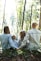man and woman holding hands together with boy and girl looking at green trees during day