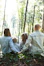 man and woman holding hands together with boy and girl looking at green trees during day