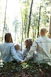 man and woman holding hands together with boy and girl looking at green trees during day