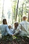 man and woman holding hands together with boy and girl looking at green trees during day
