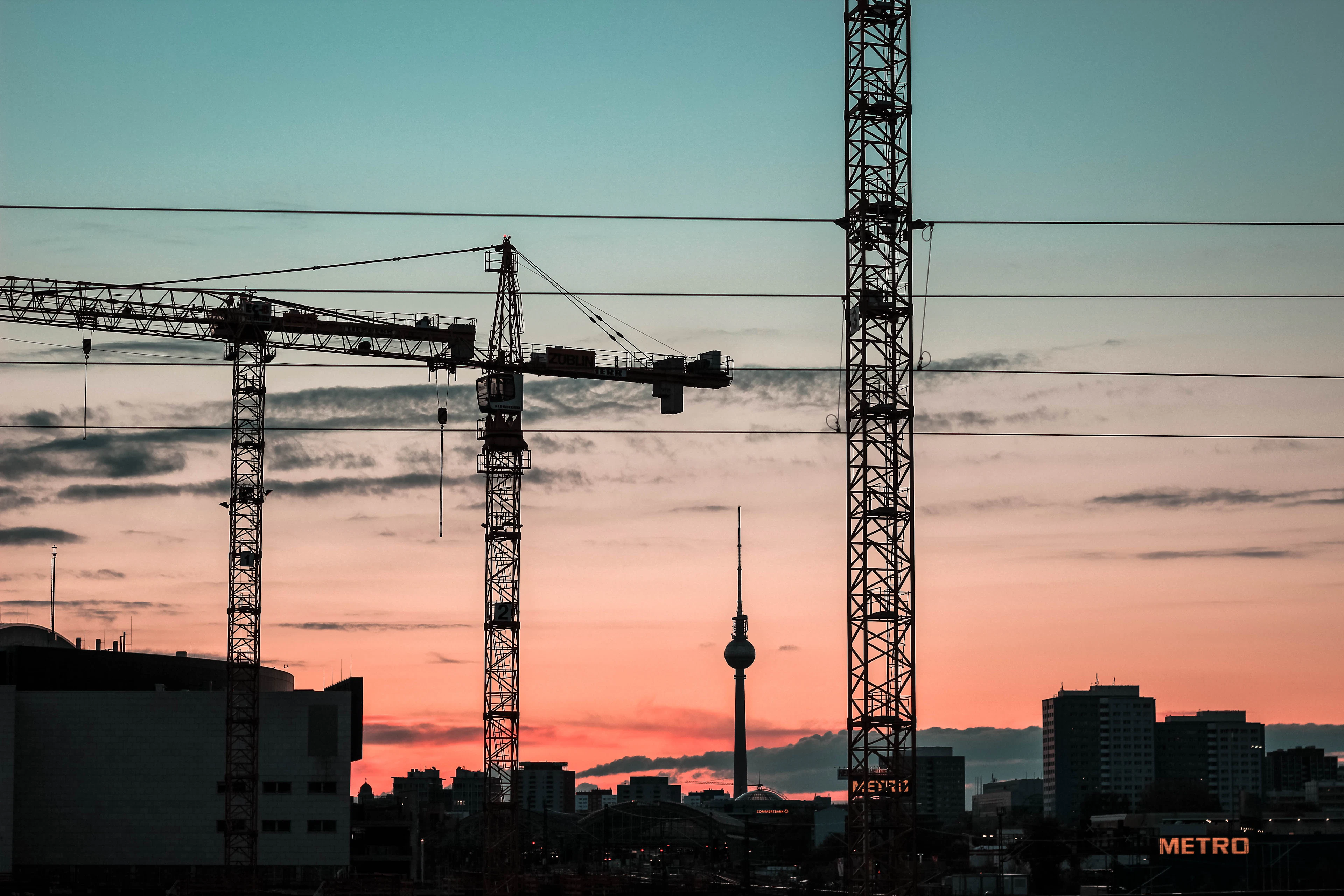 Grues de chantier sur la ville au coucher du soleil