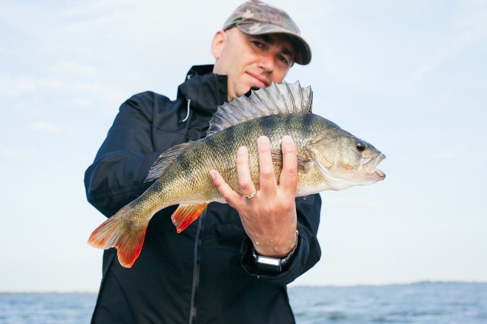 Mann mit grauem Fisch und Ozeanhintergrund