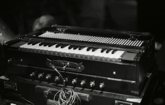 Close-up of a tabla and harmonium on a rustic wooden table