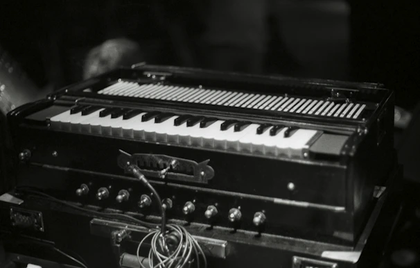 Close-up of a tabla and harmonium on a rustic wooden table
