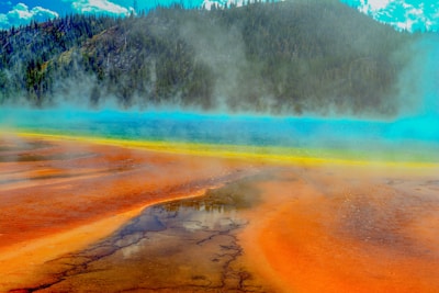 Close-up of a microbial mat shimmering in a hot spring's mineral-rich water.