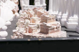 A collection of 3D printed miniature architectural models arranged on a wooden table.