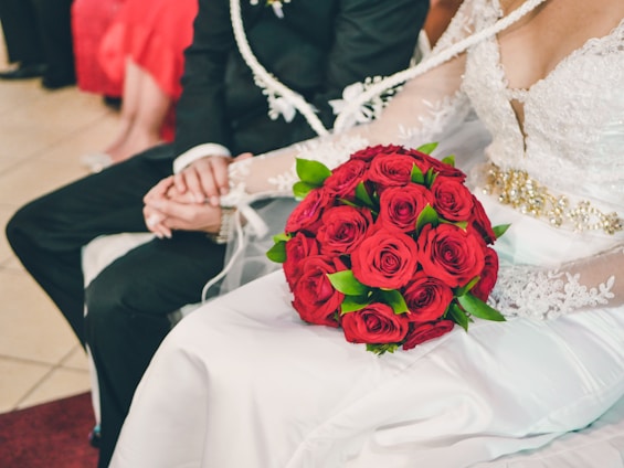 Bride and groom holding hands surrounded by elegant wedding decorations and soft lighting.