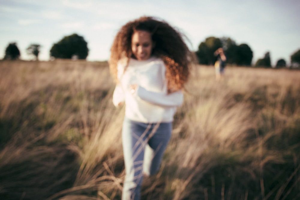 Mujer corriendo en el campo de hierba durante el día