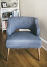 close up photo of a grey padded chair inside a room