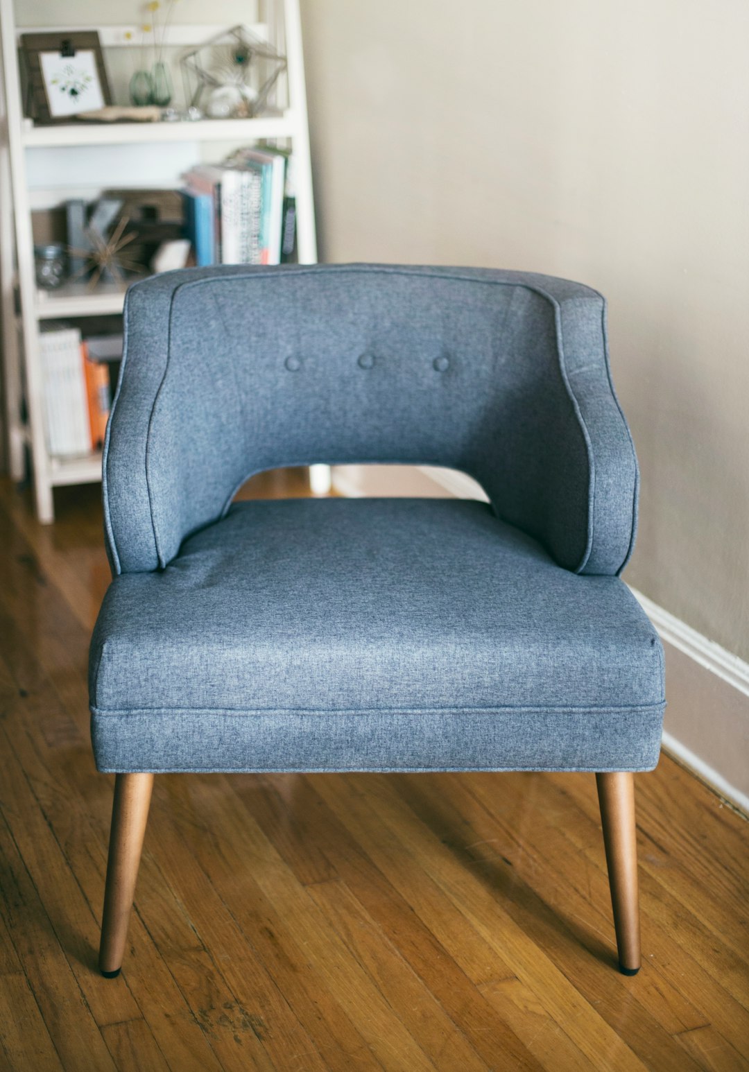  person taking photo of grey padded chair inside room sofa