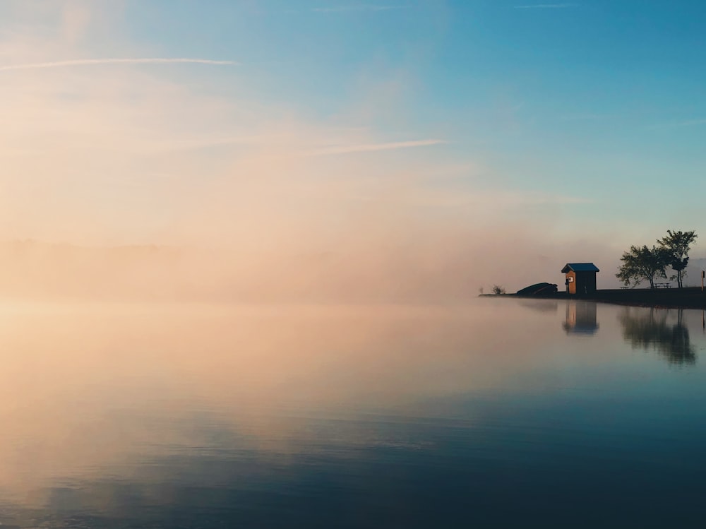 brown house beside large calm body of water