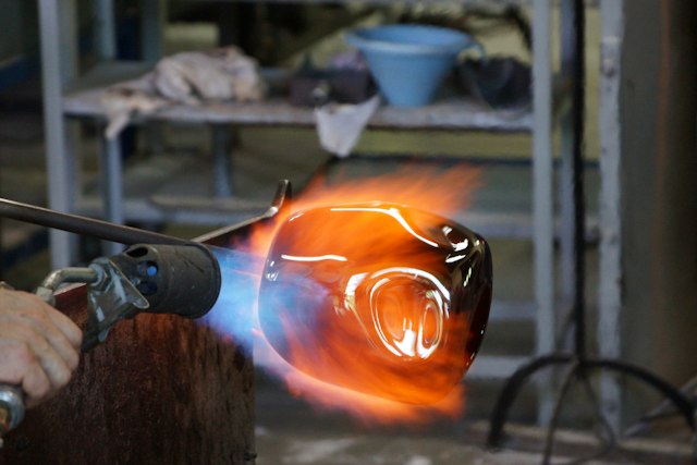 Artist working with a torch at a bench