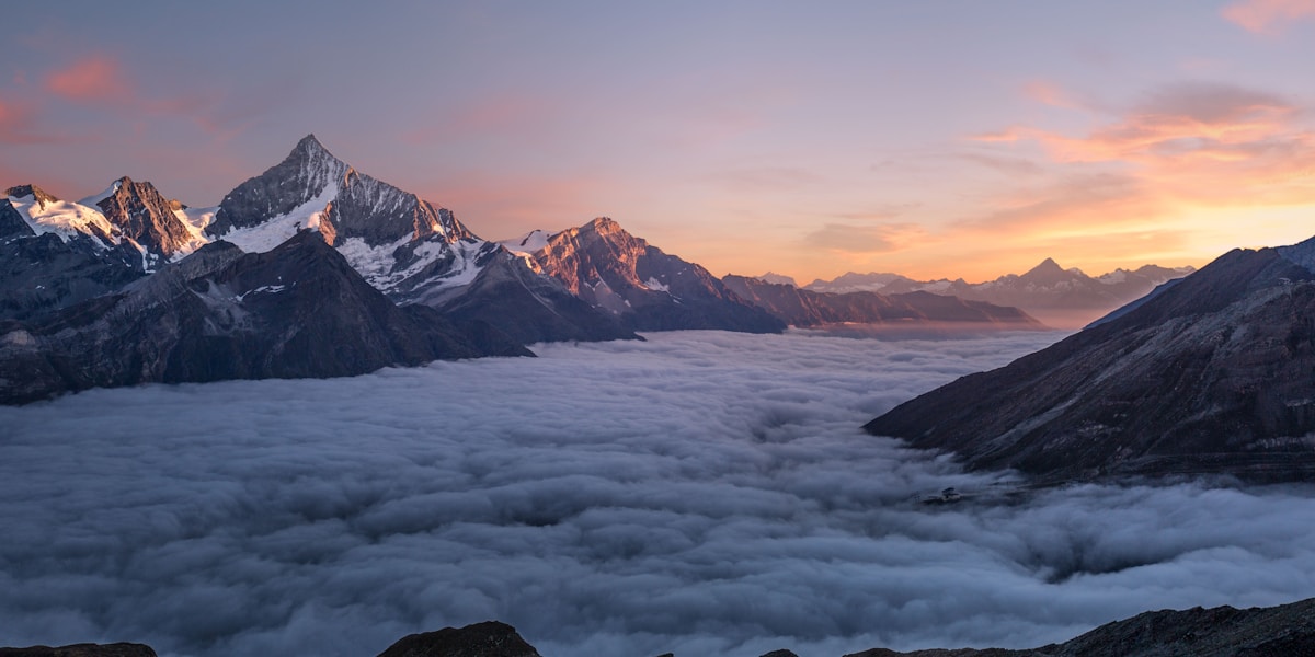 A beautiful landscape with mountains and a lake at sunset