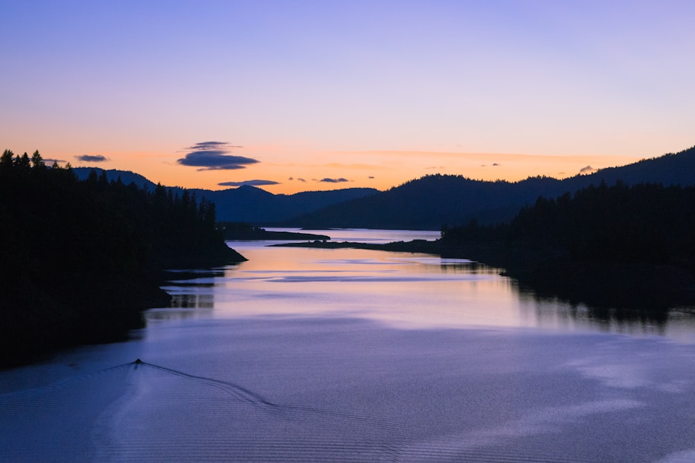 silhouette of body of water near mountain