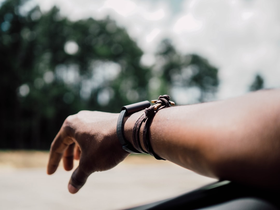 selective focus photography of person's arm with three leather bracelets